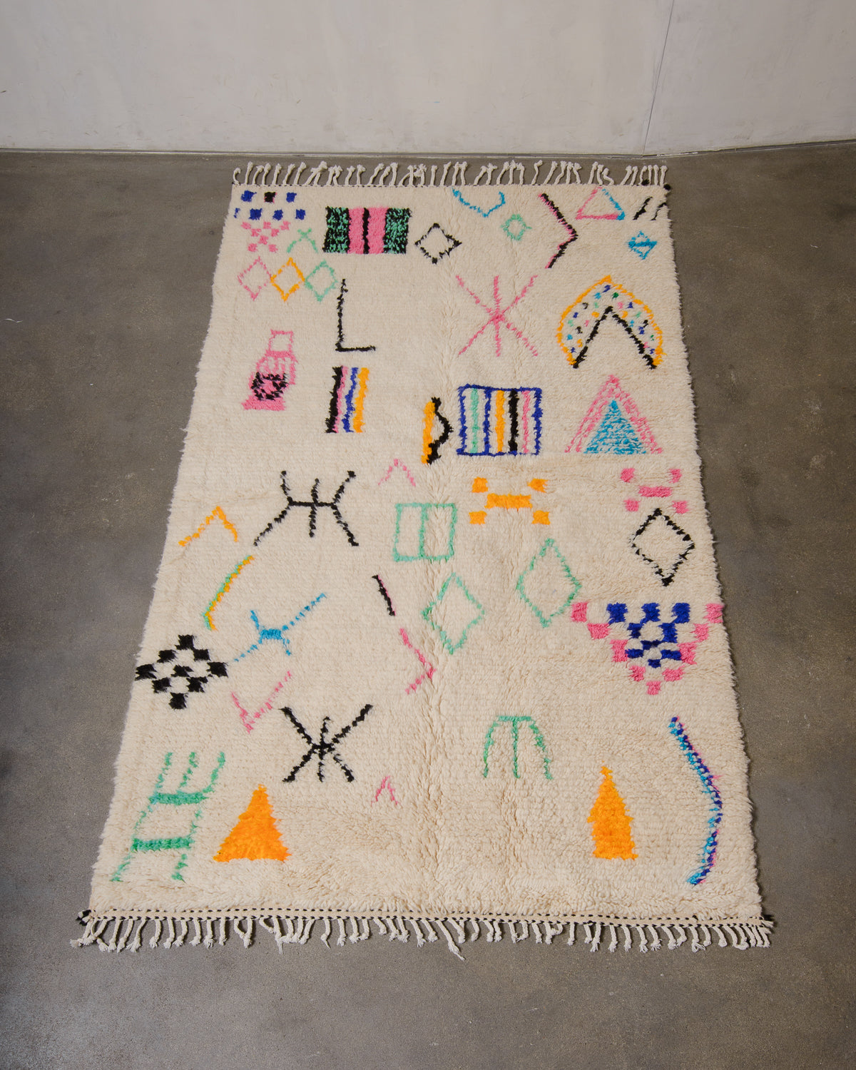 Berberlin Azilal rug made of fluffy wool and cotton, laying flat on a concrete floor.